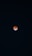 The image features a lunar eclipse with the moon appearing reddish against a dark night sky. Stars are faintly visible across the background.