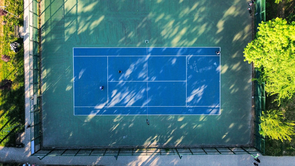 an aerial view of a tennis court in a park