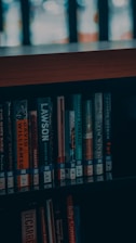 a bookshelf filled with lots of books next to a window