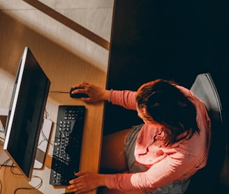 a woman sitting at a desk using a computer