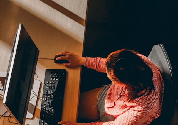 a woman sitting at a desk using a computer