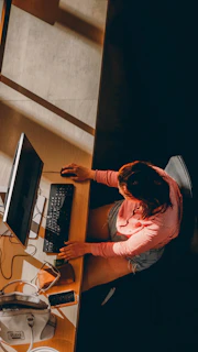 a woman sitting at a desk using a computer