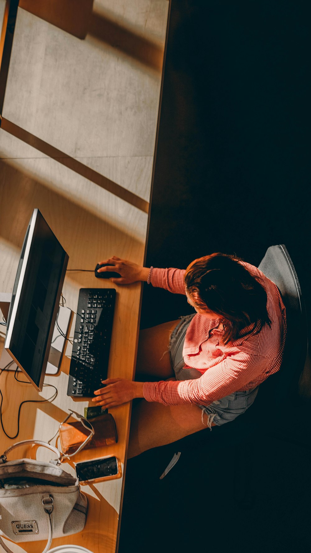 a woman sitting at a desk using a computer