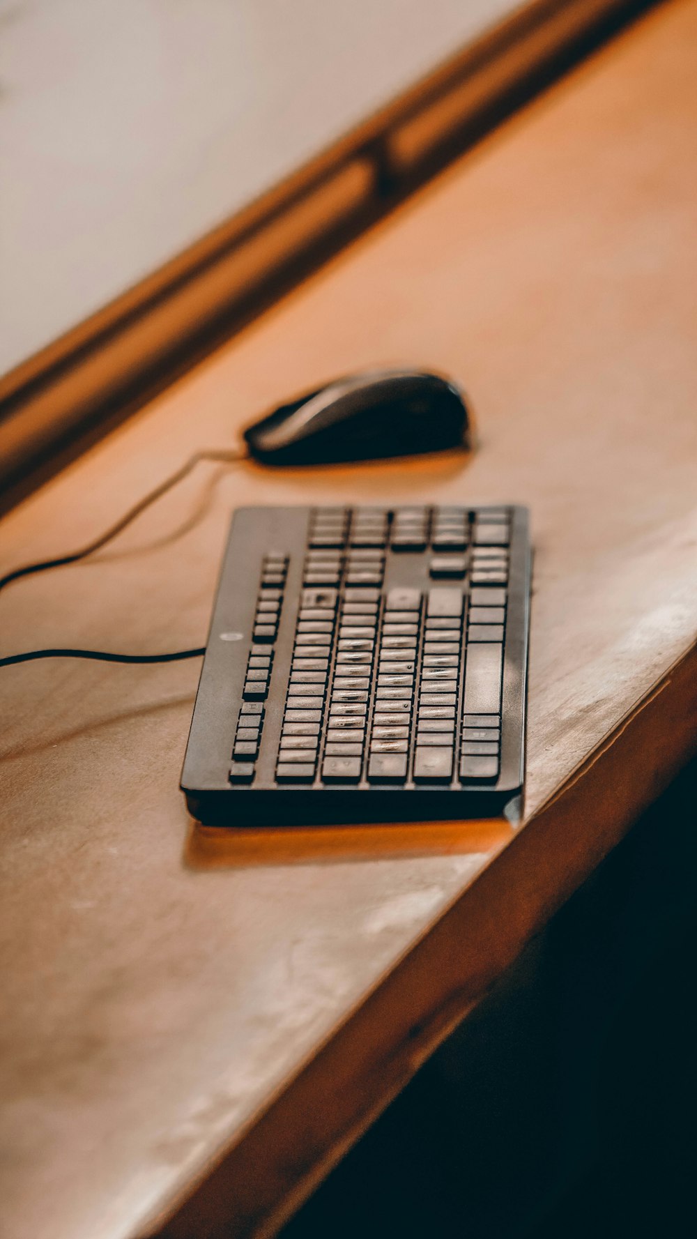 a computer keyboard sitting on top of a wooden desk