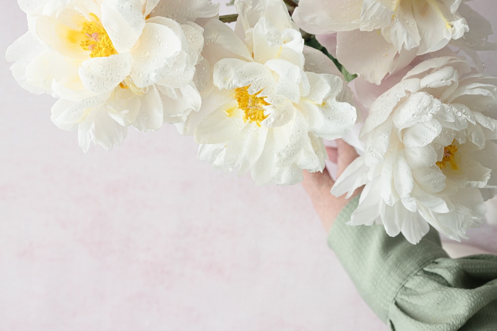 une personne tenant un bouquet de fleurs blanches