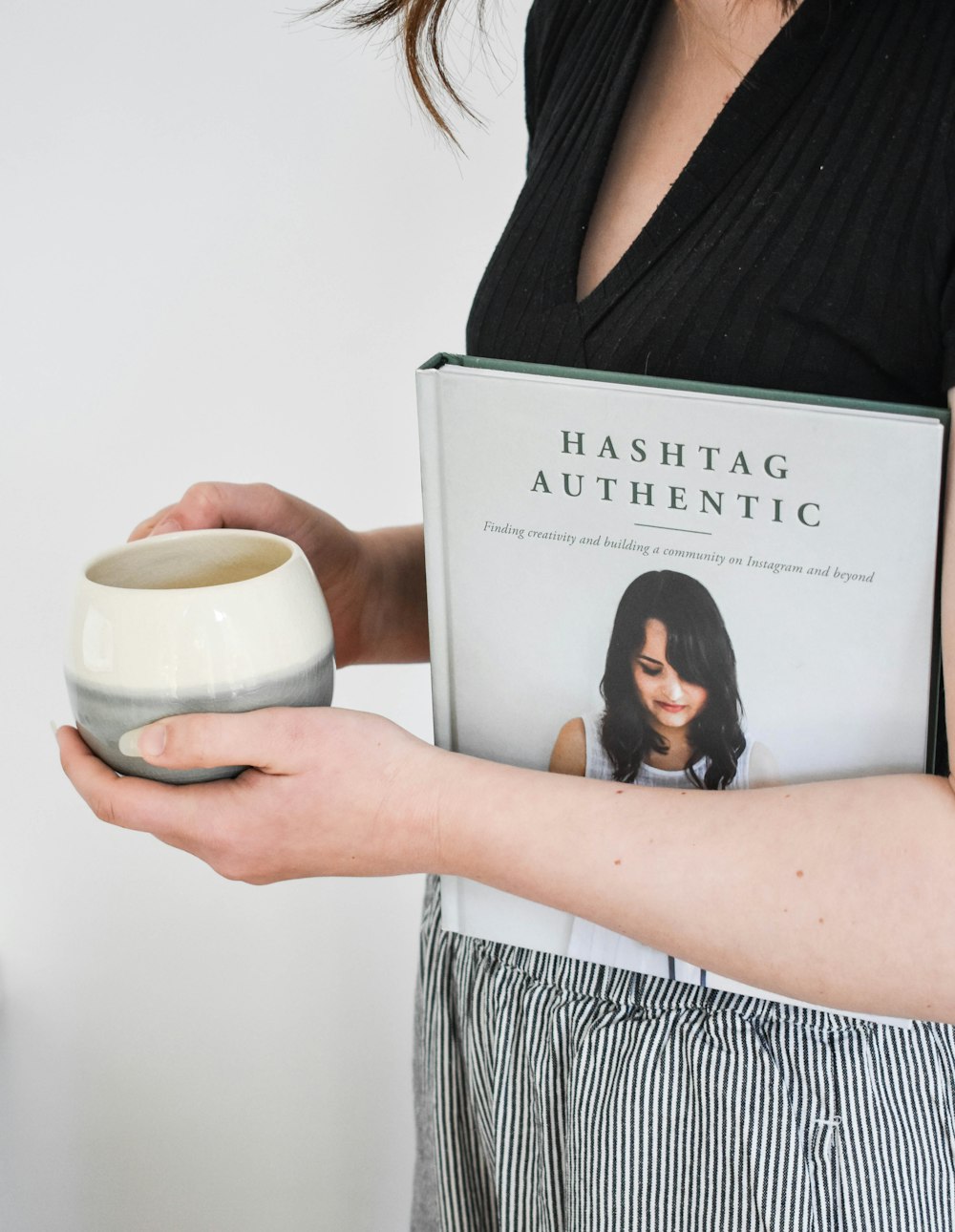 a woman holding a book and a bowl