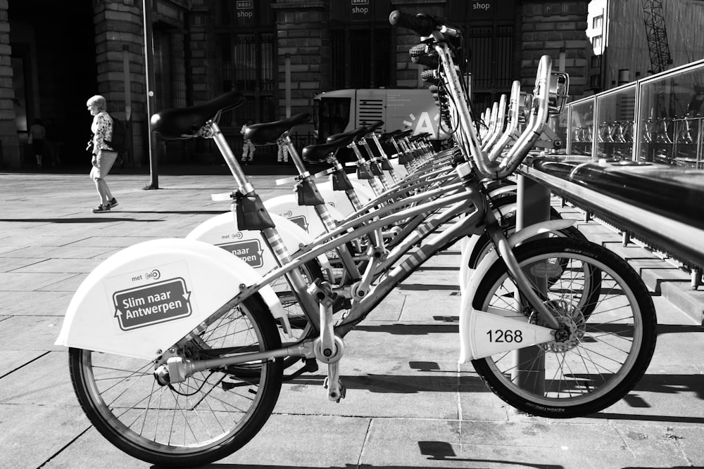 a row of bikes parked next to each other on a sidewalk