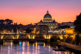 a river with a bridge and a building in the background
