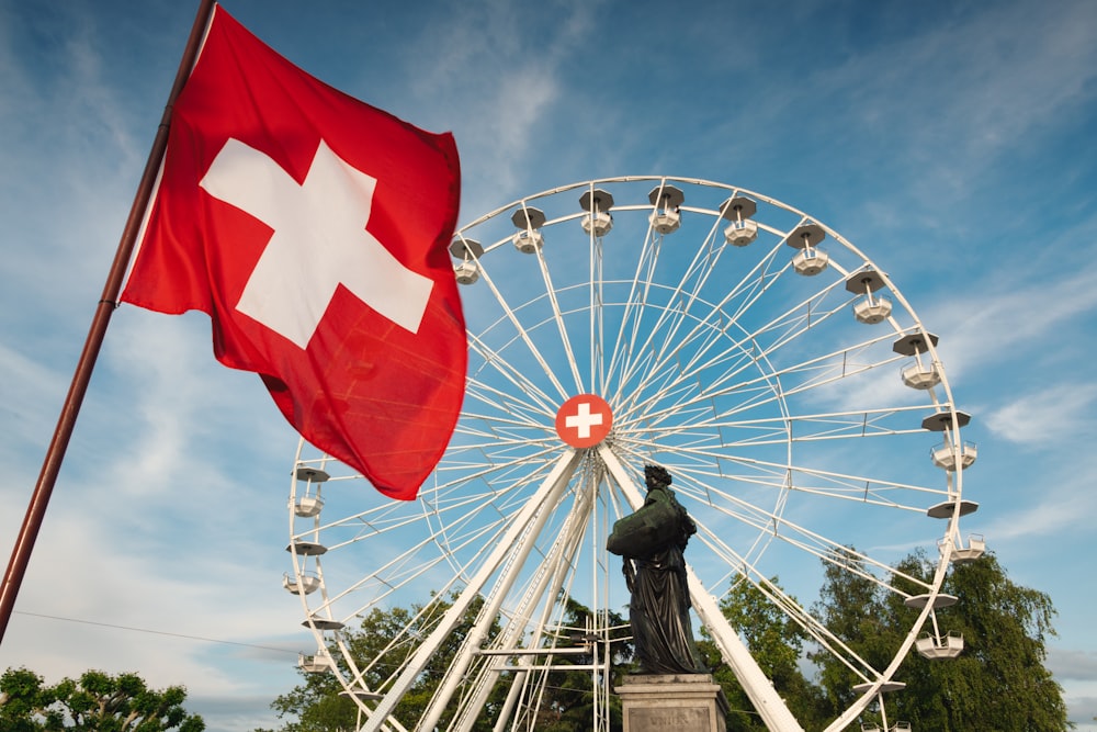 una grande ruota panoramica seduta accanto a una statua