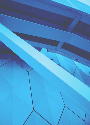 A modern architectural blueprint overlaying a deep cobalt blue background, symbolizing precision and creativity.
