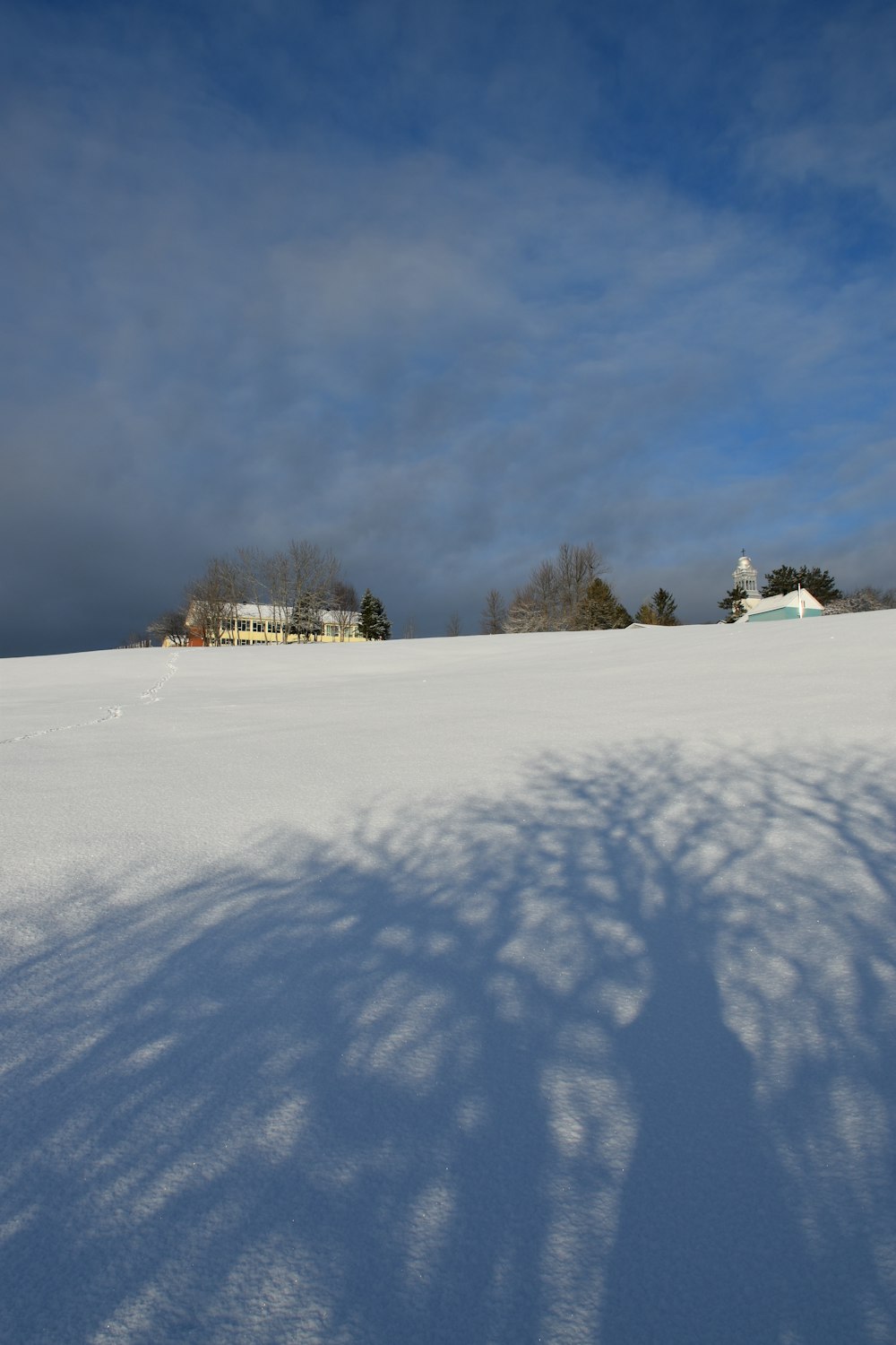 a snow covered field with a house in the distance