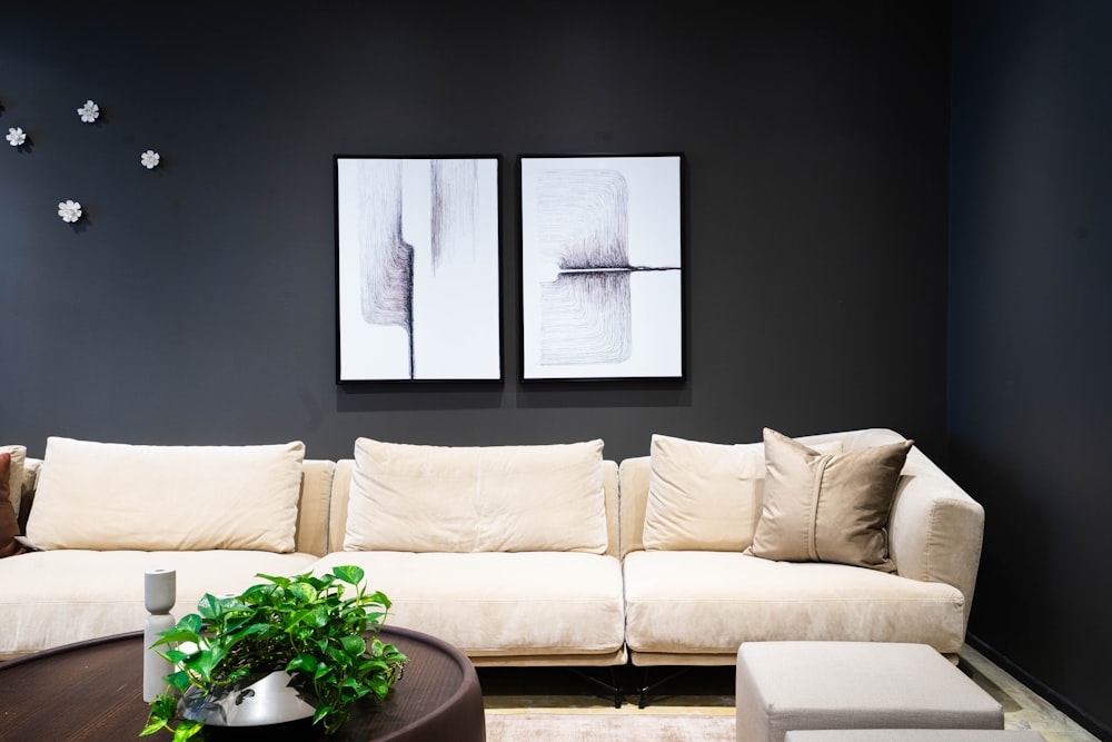 a living room with a white couch and two pictures on the wall