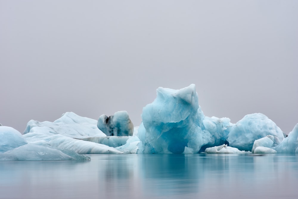 a group of icebergs floating on top of a body of water