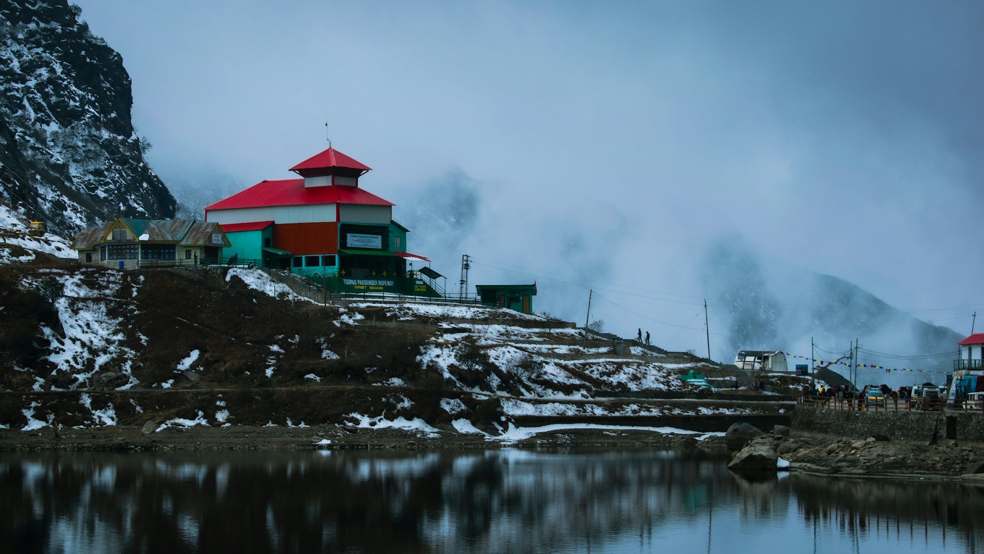 a red and white house sitting on top of a snow covered hill