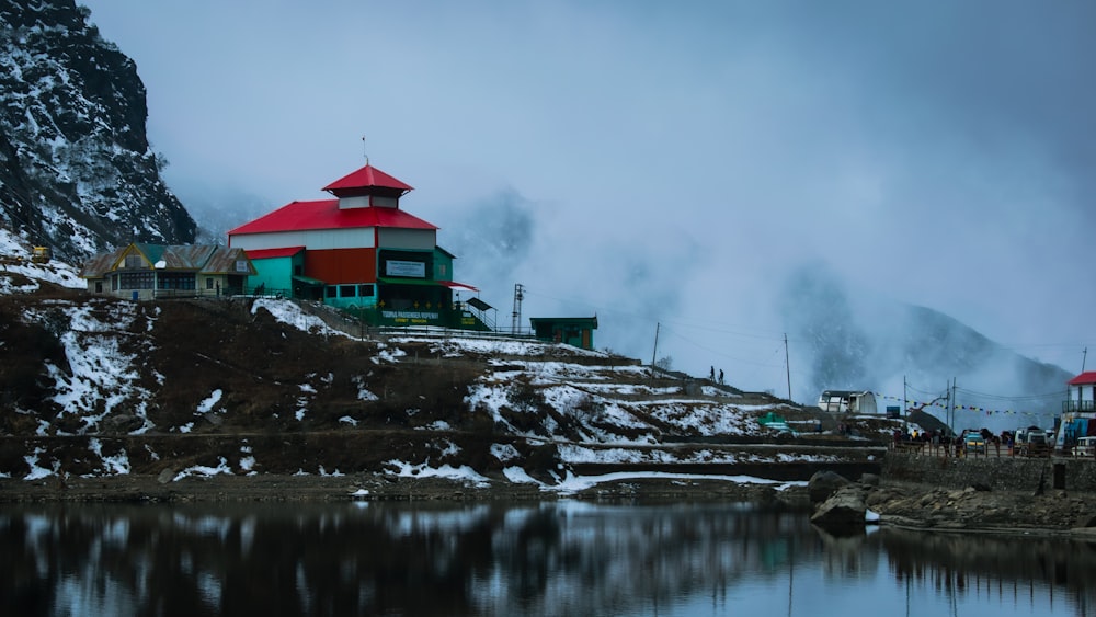 a red and white house sitting on top of a snow covered hill