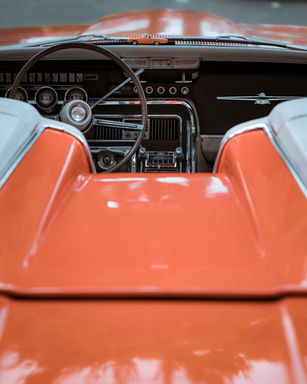 the interior of an orange car with a steering wheel