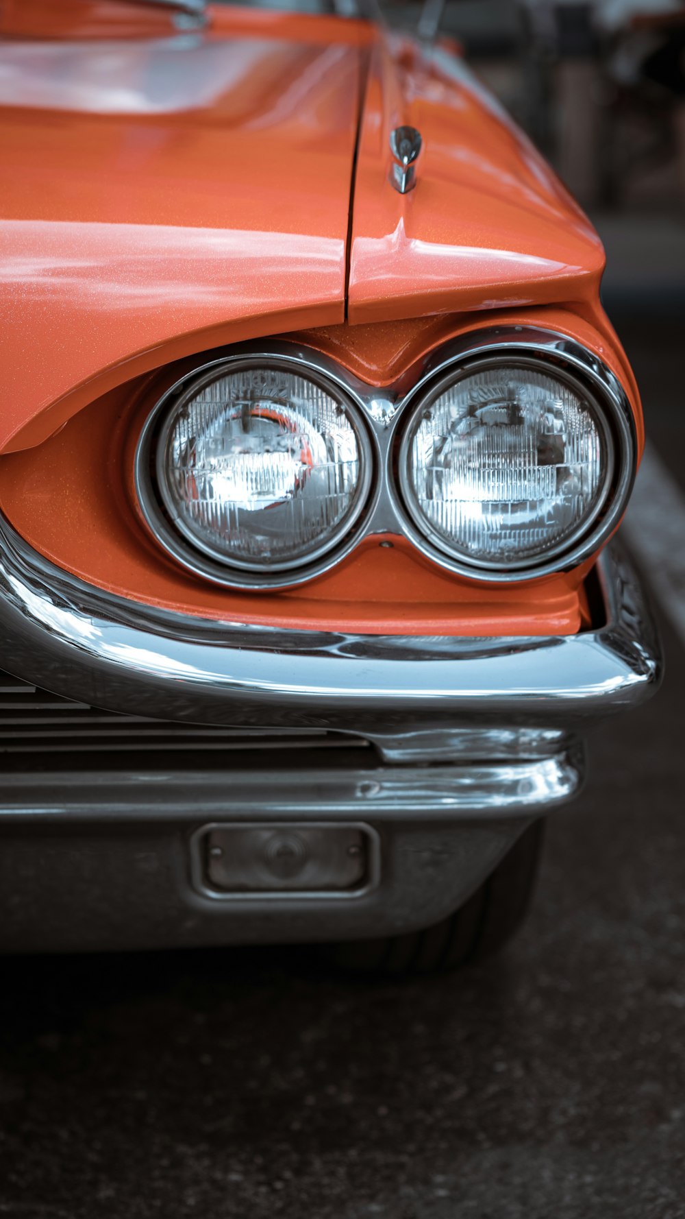 a close up of the front of an orange car