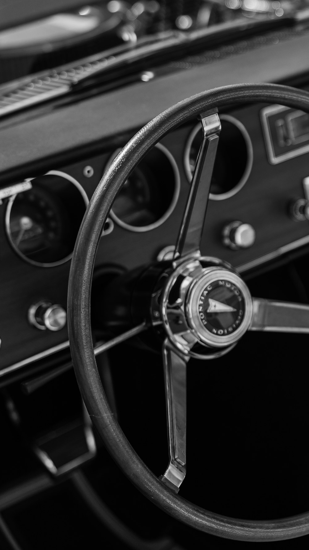 uma foto em preto e branco de um volante e painel de instrumentos