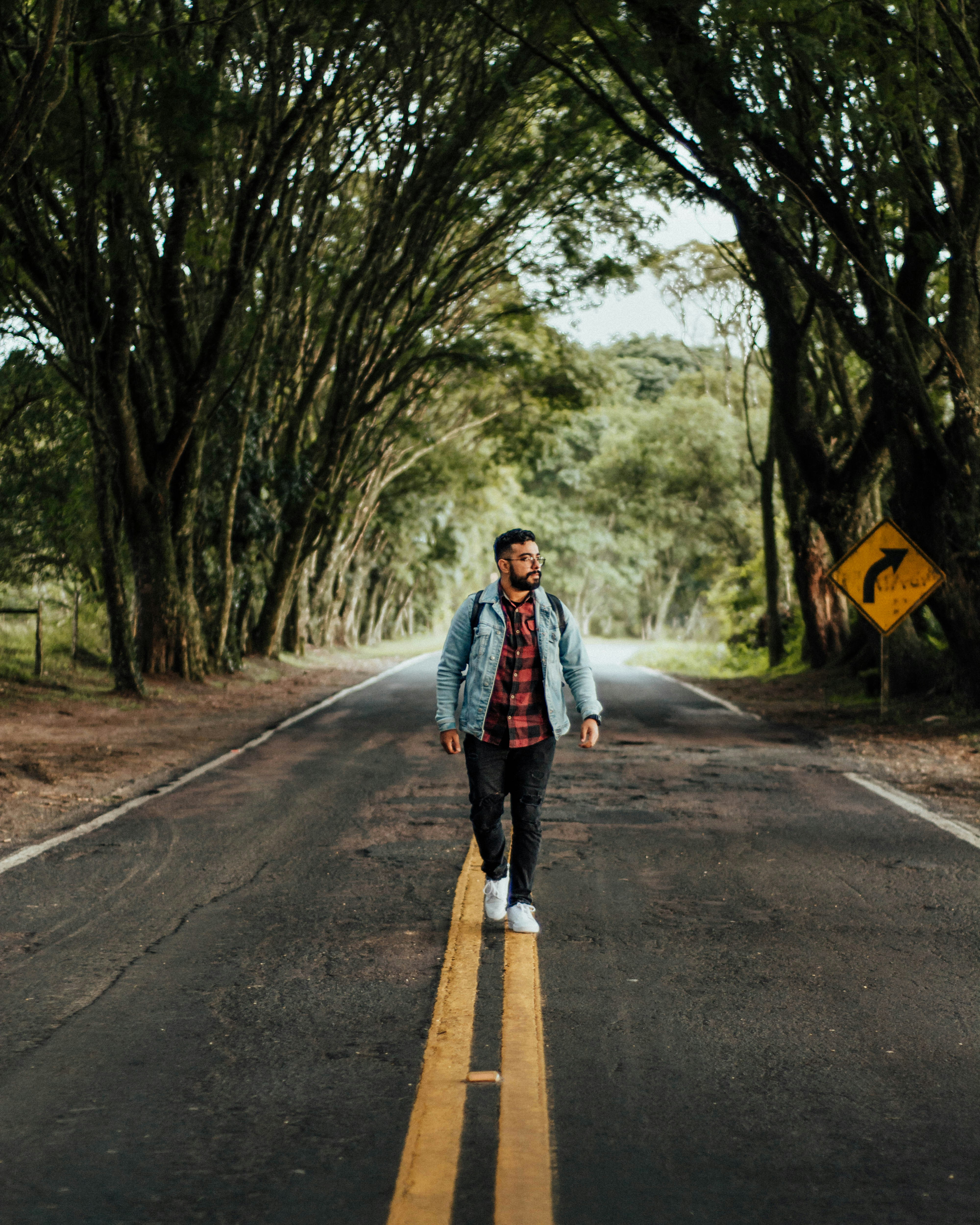 a man walking down the middle of a road