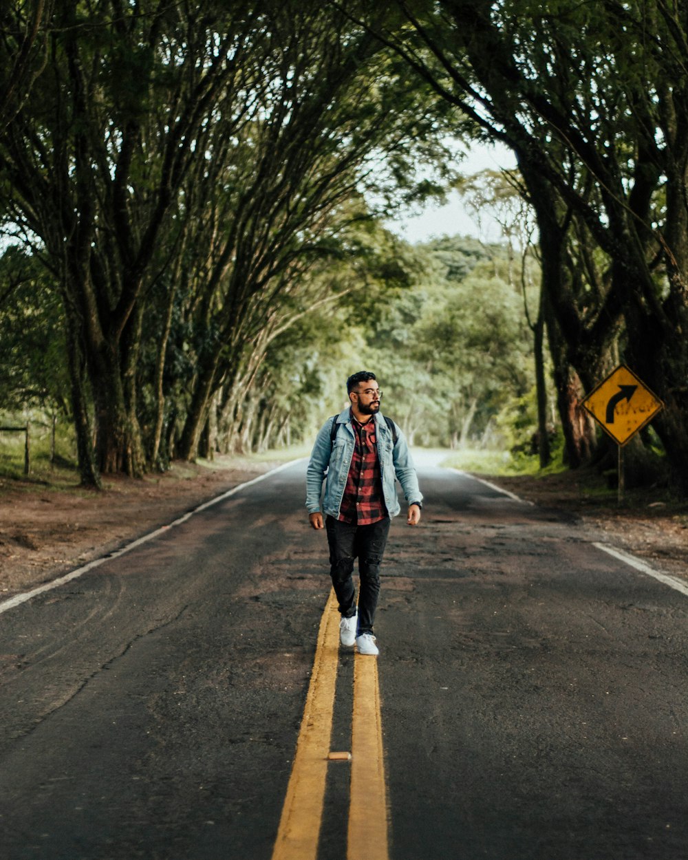 a man walking down the middle of a road