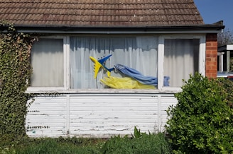 a window with a blue and yellow kite in it