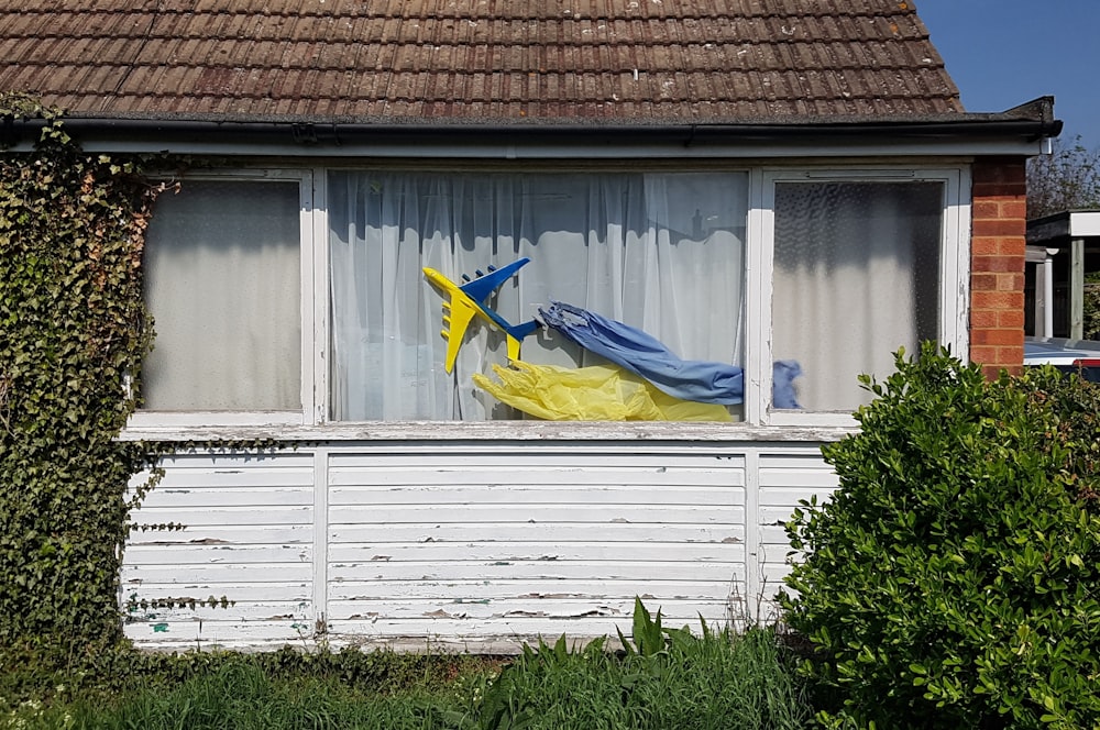 a window with a blue and yellow kite in it