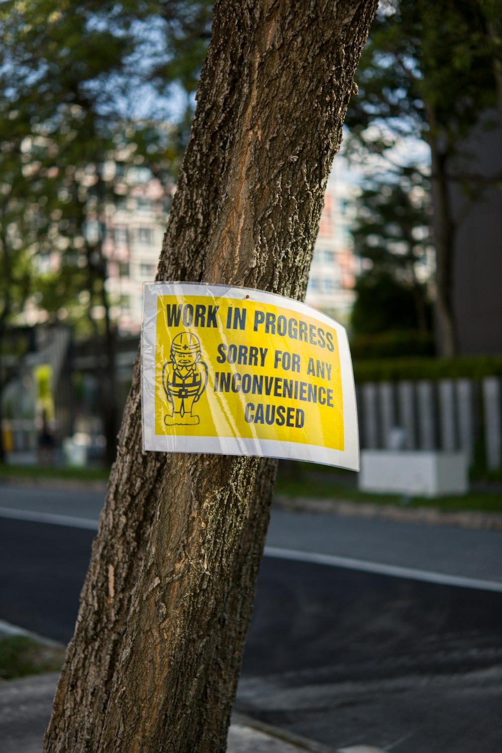 a work in progress sign attached to a tree