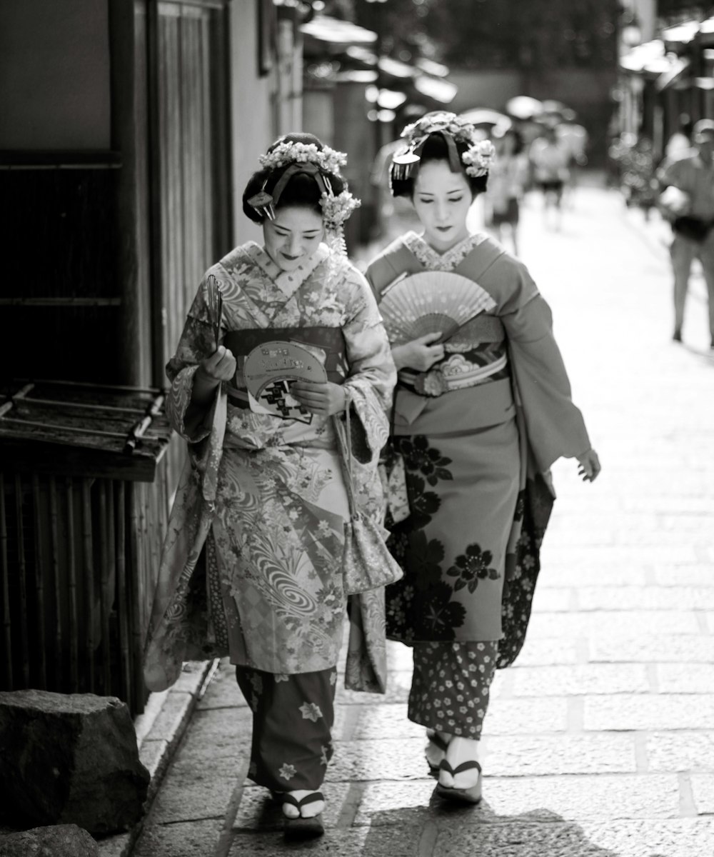 a couple of women walking down a street next to each other