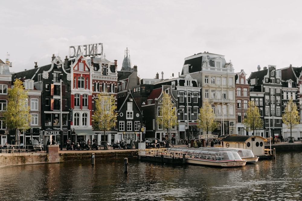 a boat floating on a river next to tall buildings