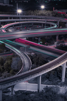 A sleek aerial view of a sprawling, illuminated highway network at dusk, symbolizing dynamic connectivity and forward momentum.