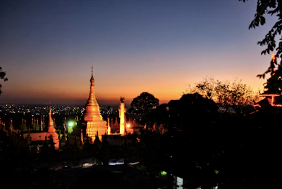 A wide shot of the Sri Hanumat Siddha Peeth temple bathed in warm golden light during sunset.