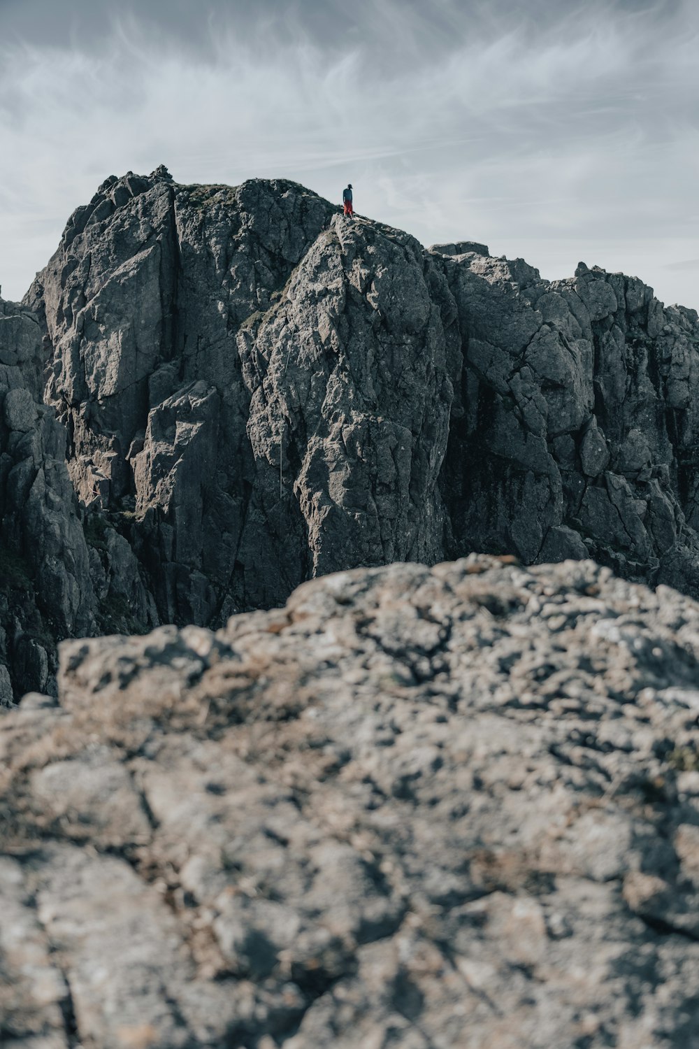 uma pessoa em pé no topo de uma montanha rochosa