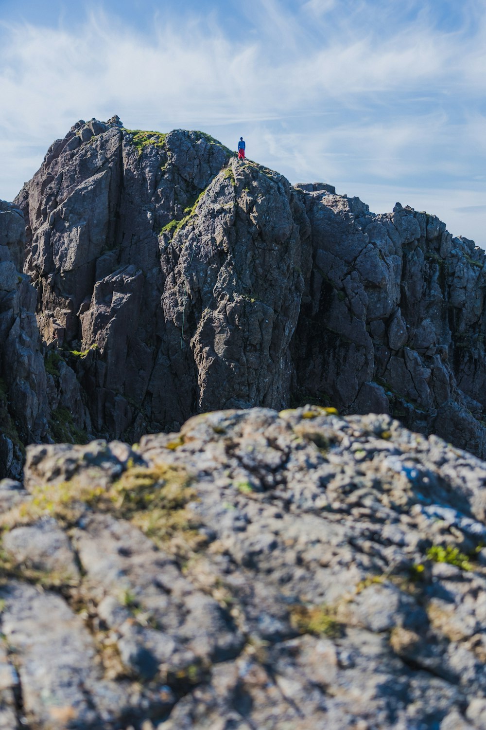 uma pessoa em pé no topo de uma montanha rochosa