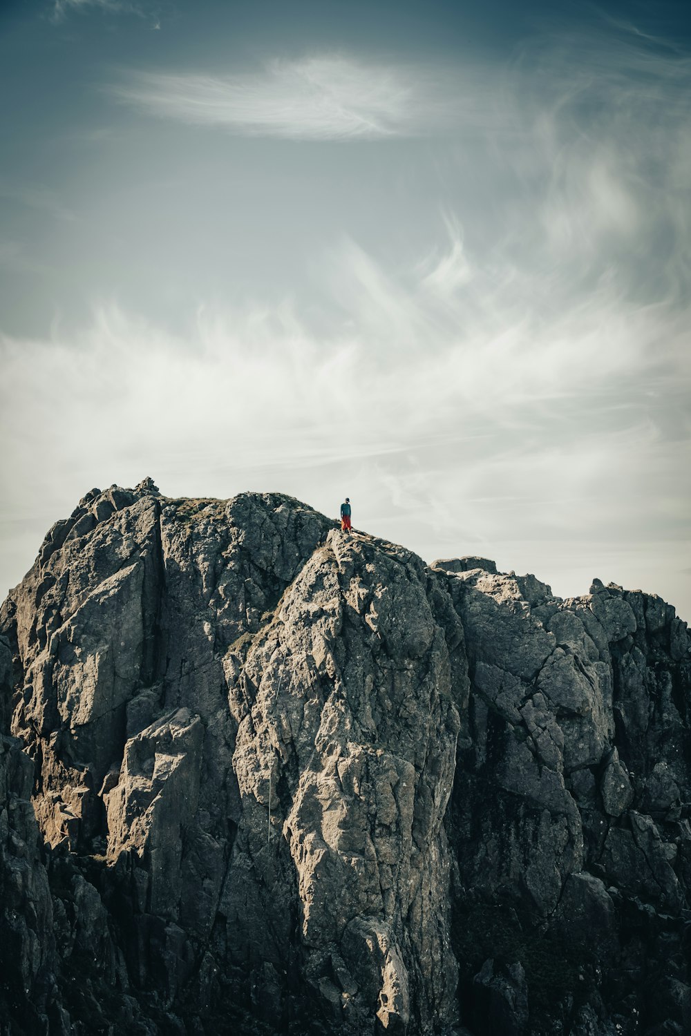 una persona seduta sulla cima di una grande roccia