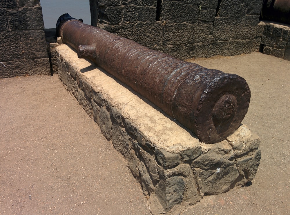 a large metal object sitting on top of a stone wall