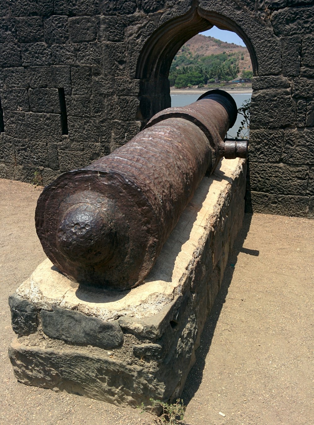 a large metal object sitting on top of a stone wall