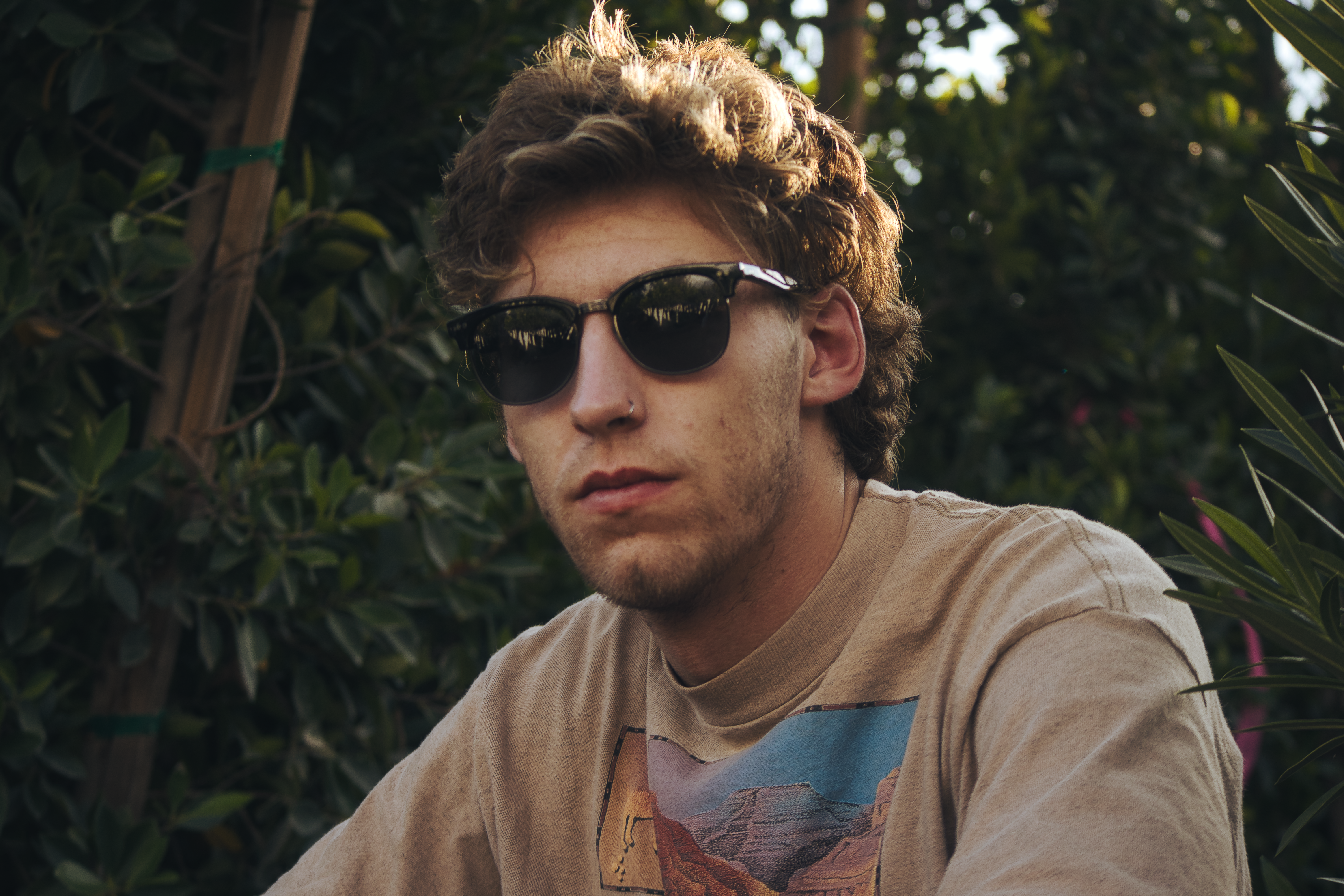 Young man with natural hair, casual outfit, outdoor background, natural light