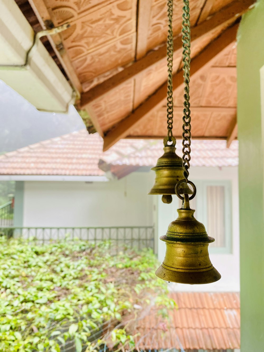 a couple of bells hanging from a roof