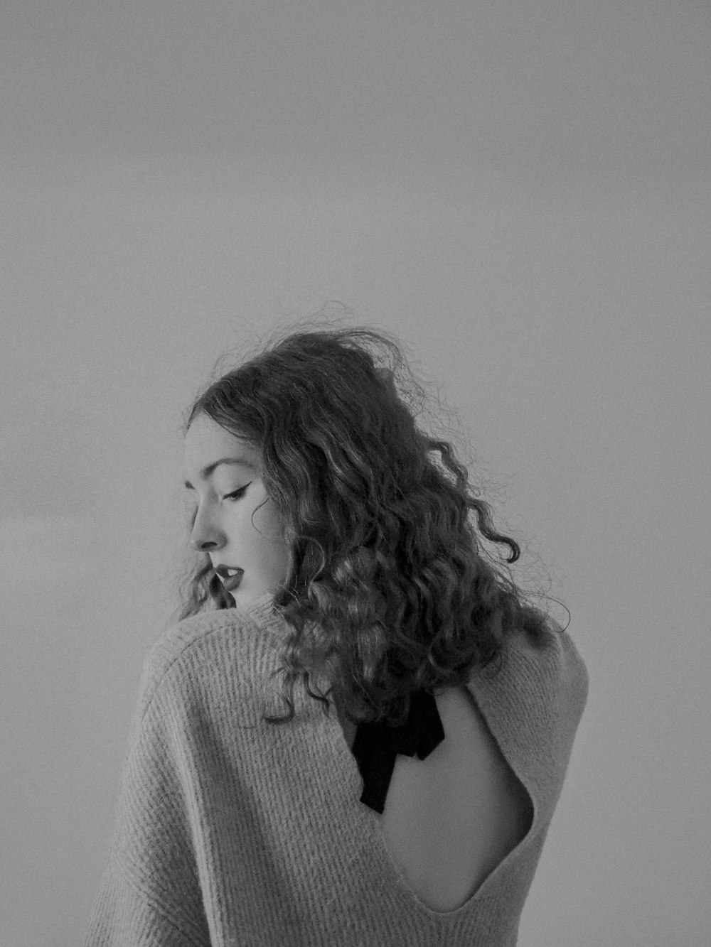 a black and white photo of a woman wearing a sweater