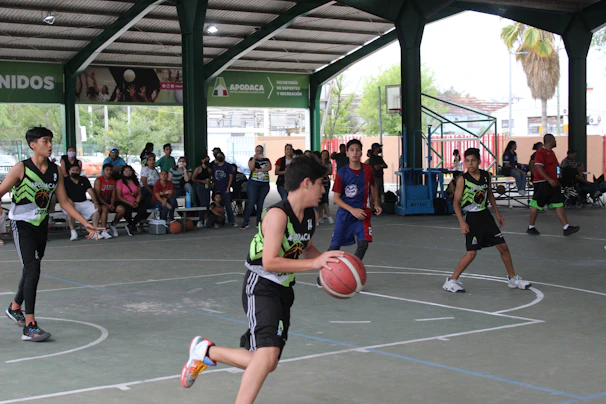 Young players practicing precise footwork drills on a bright indoor basketball court.