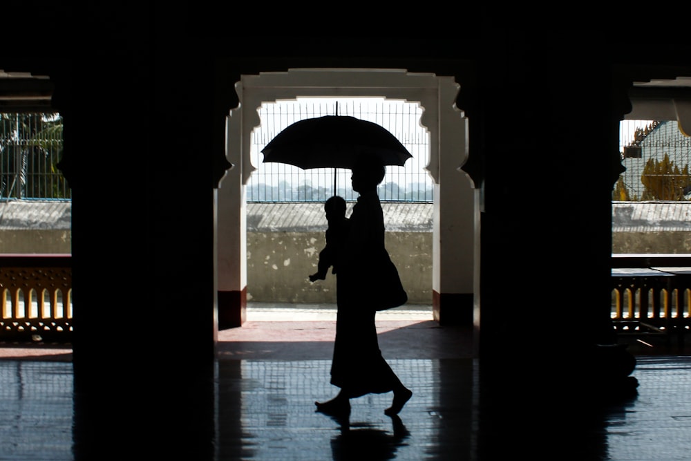 a silhouette of a person holding an umbrella