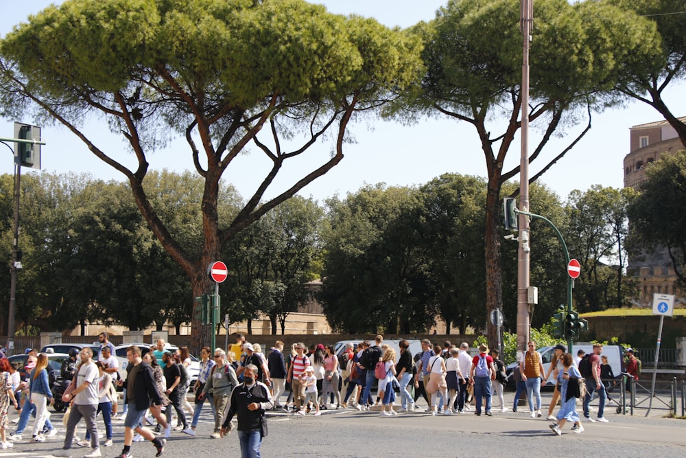 Un grande gruppo di persone che attraversano una strada