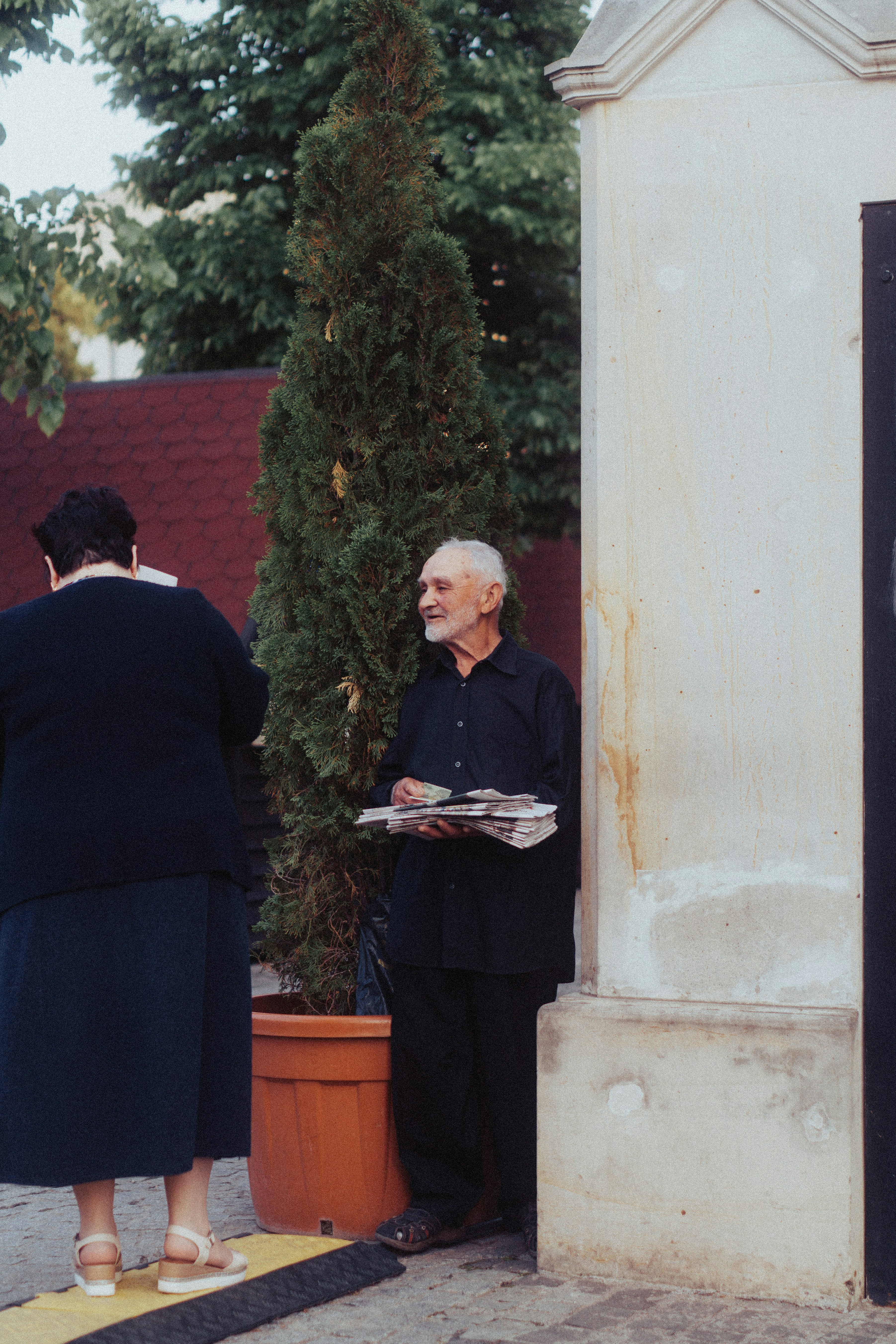 a man standing next to a woman holding a newspaper