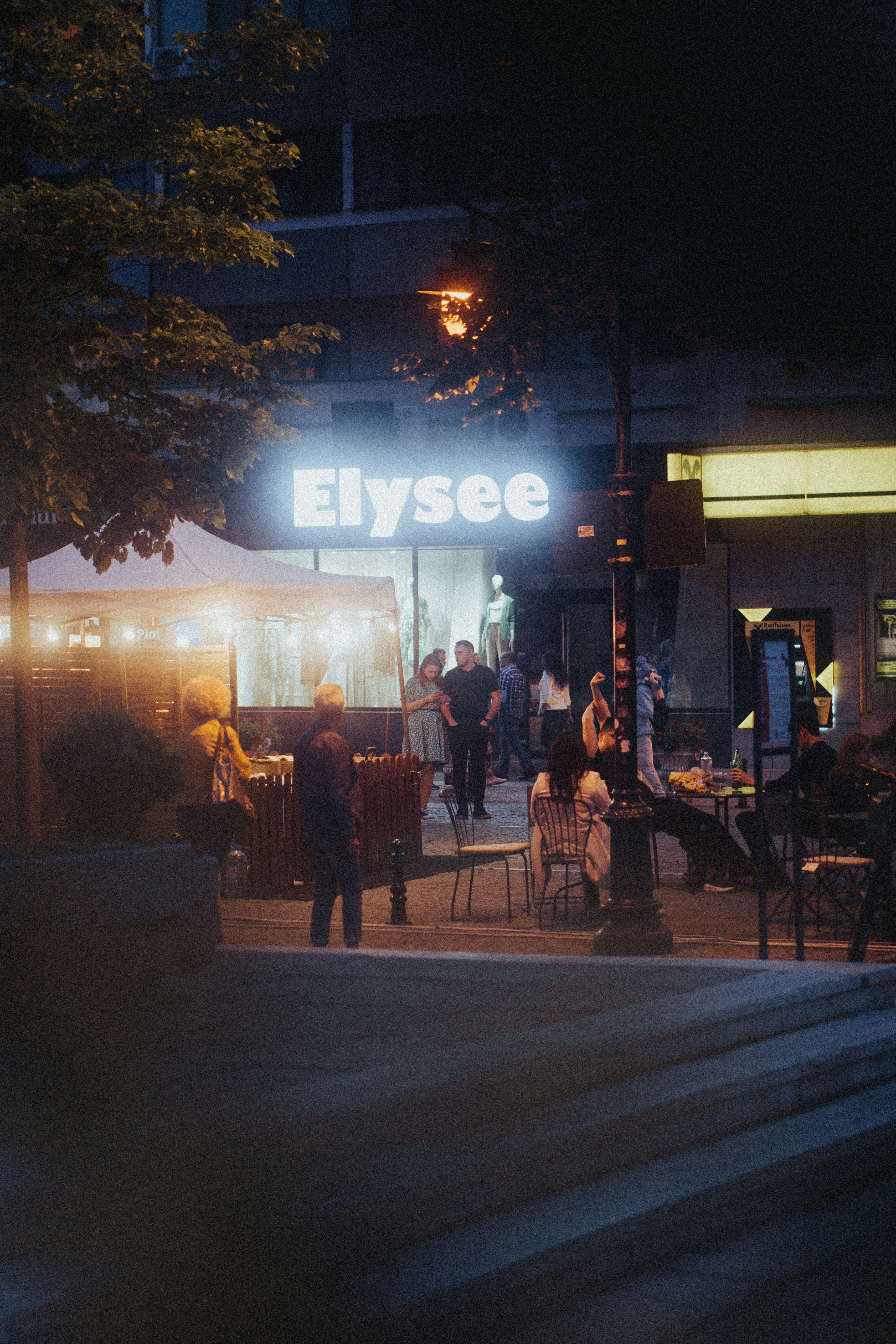 a group of people sitting at a table outside of a building