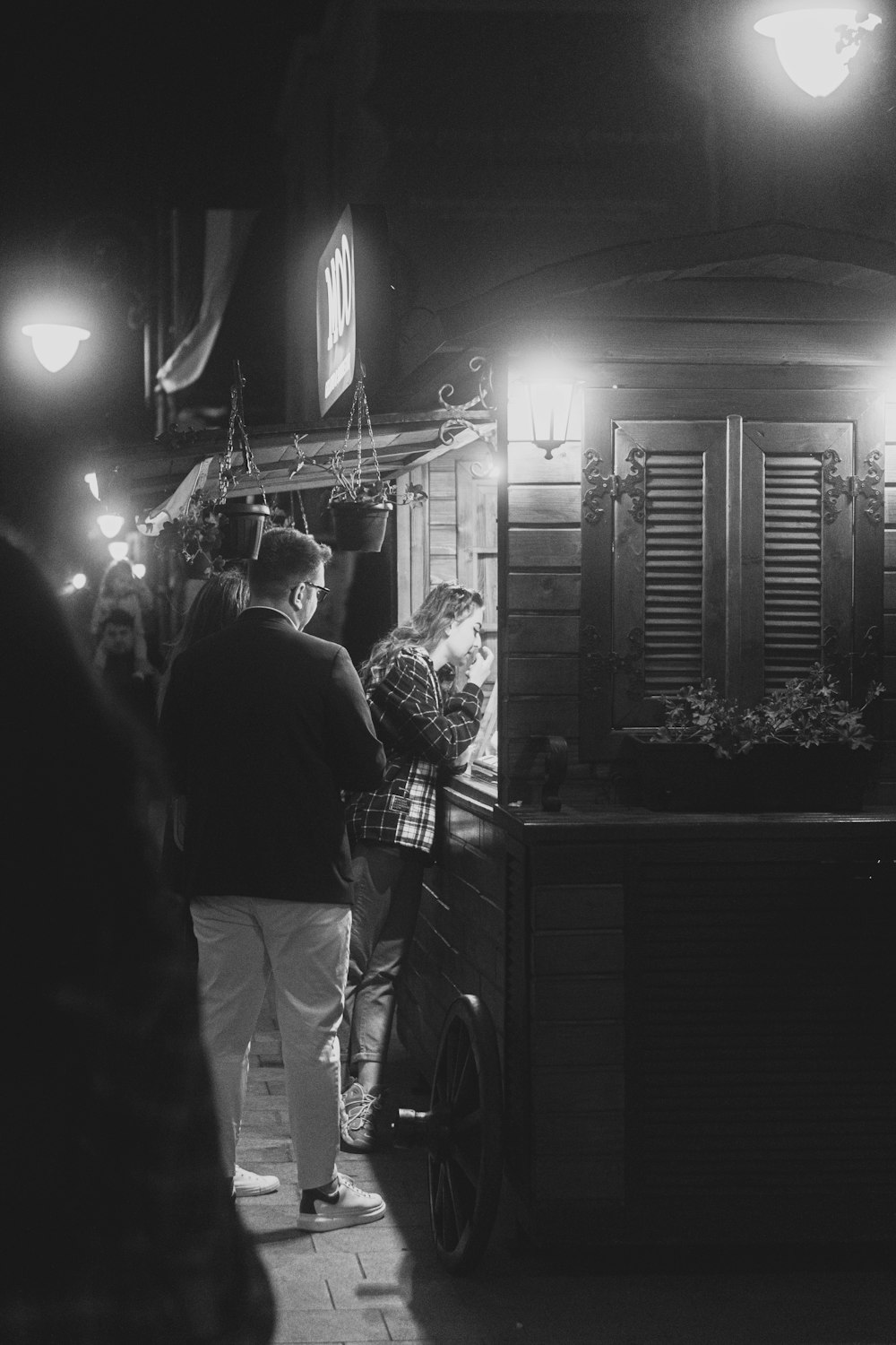 a black and white photo of people standing outside of a building