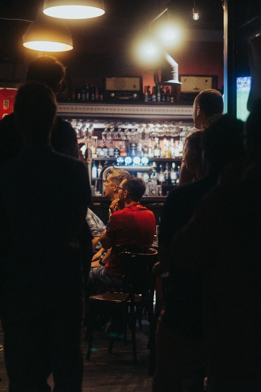 a group of people standing around a bar