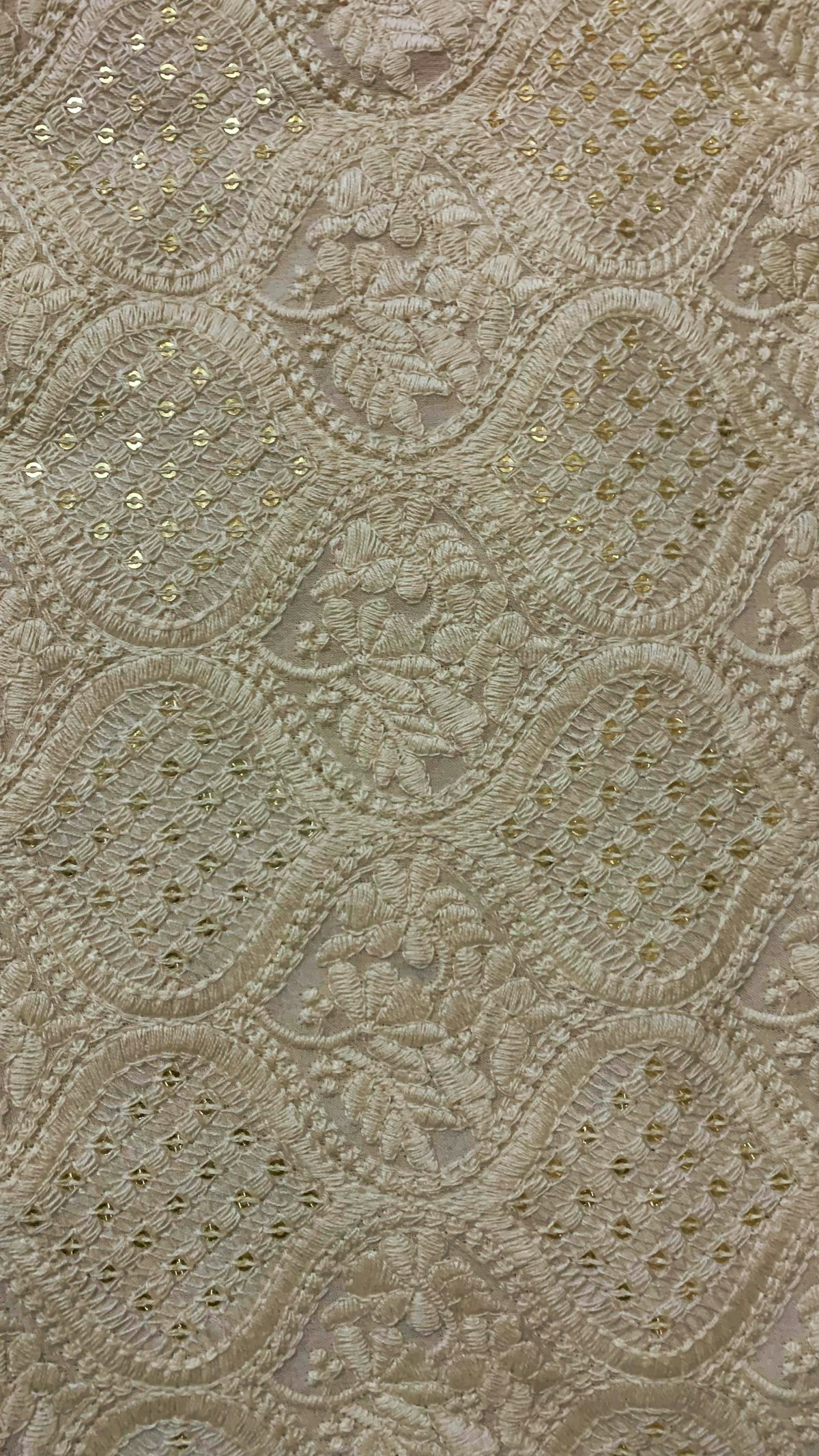 A close up of a bed with embroidery pattern