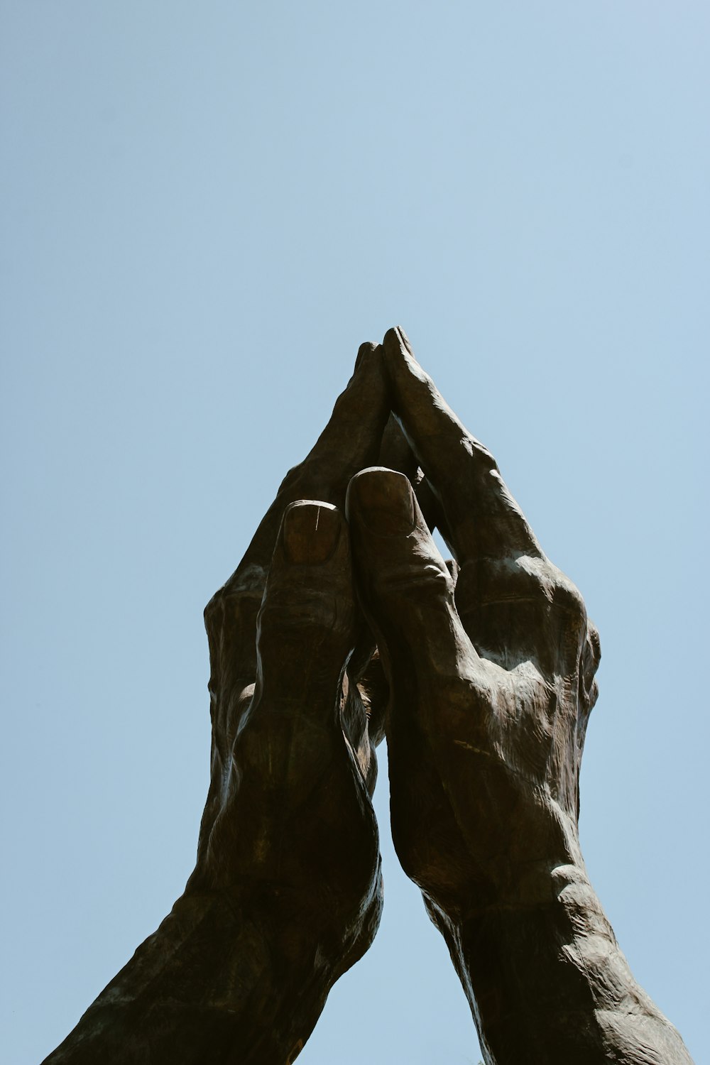 una estatua de dos manos que se elevan hacia el cielo