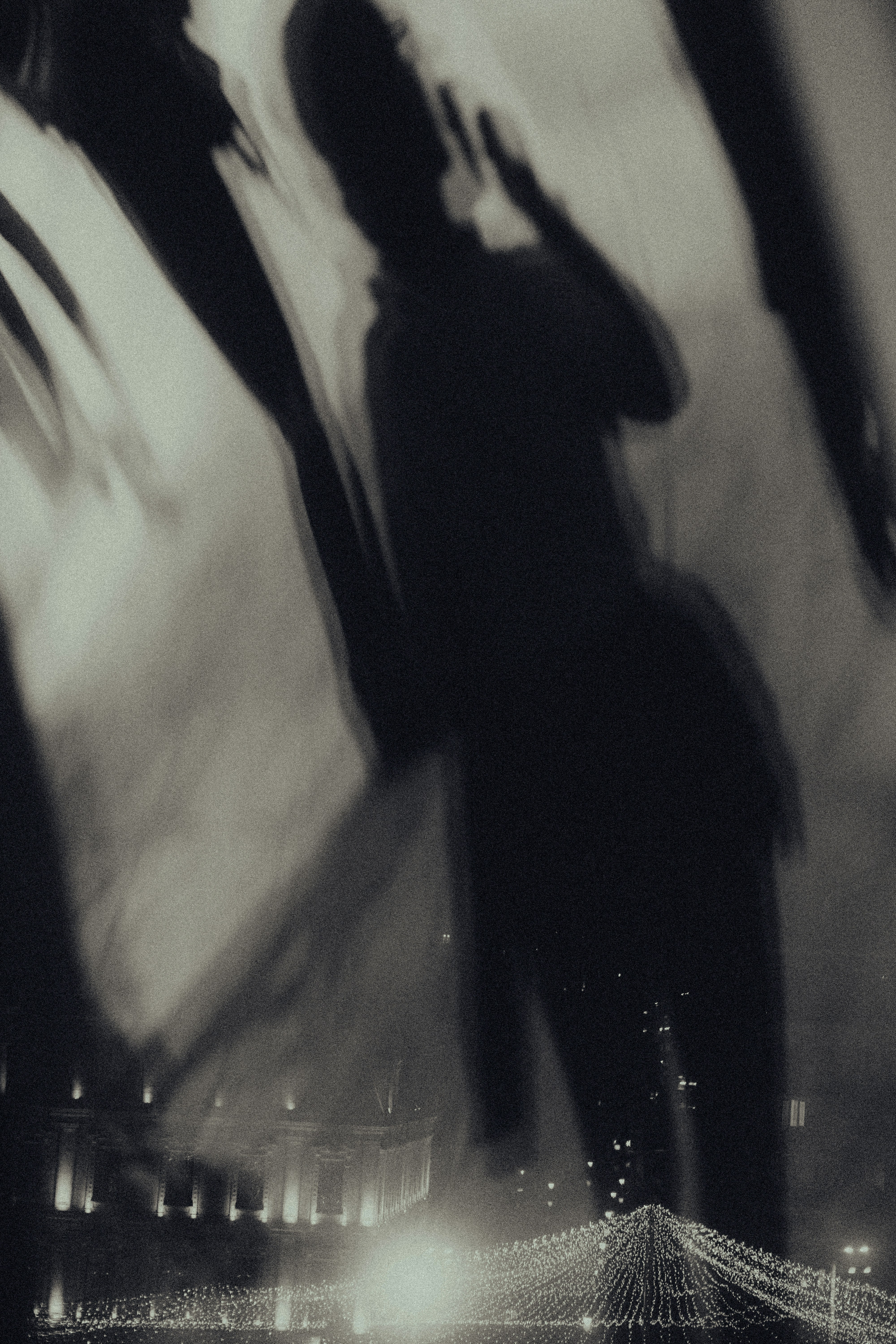 a black and white photo of a man talking on a cell phone