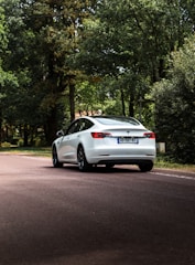 A driving instructor guiding a student in a car on a quiet road.